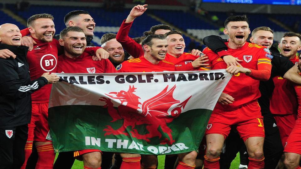 Η ποδοσφαιρική ομάδα της Ουαλίας στην εικόνα να πανηγυρίζει με τη σημαία. Είναι στα σημερινά προγνωστικά η εθνική.